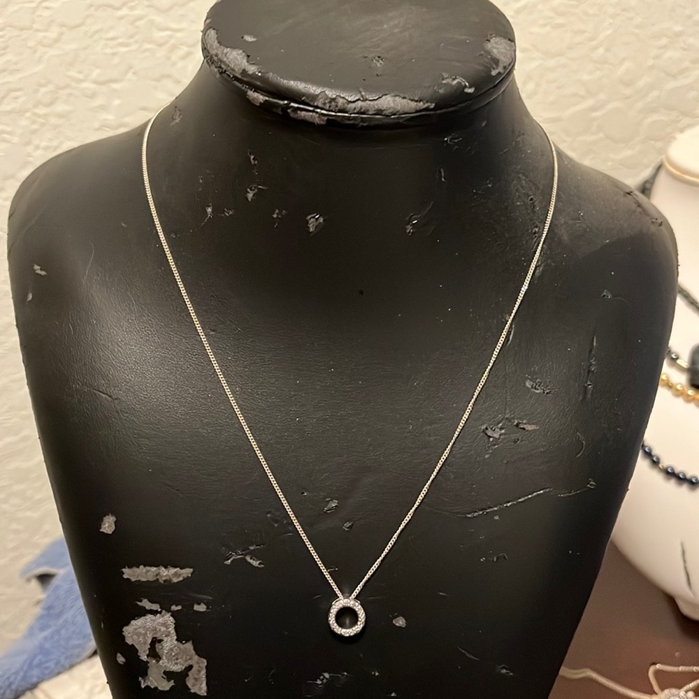 Round silver pendant with diamond chips on a silver chain